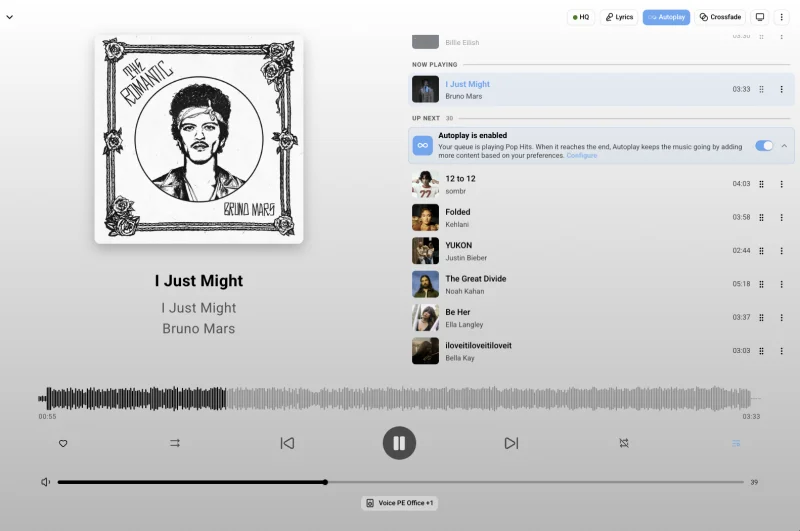 Screenshot of the Music Assistant now-playing screen showing ‘I Just Might’ by Bruno Mars, from the album ‘I Just Might,’ with album art and a waveform progress bar. An ‘Up Next’ queue with Autoplay enabled lists several upcoming tracks. Playback controls for shuffle, previous, pause, next, and repeat appear at the bottom, along with a volume slider and the connected speaker, ‘Voice PE Office #1.’